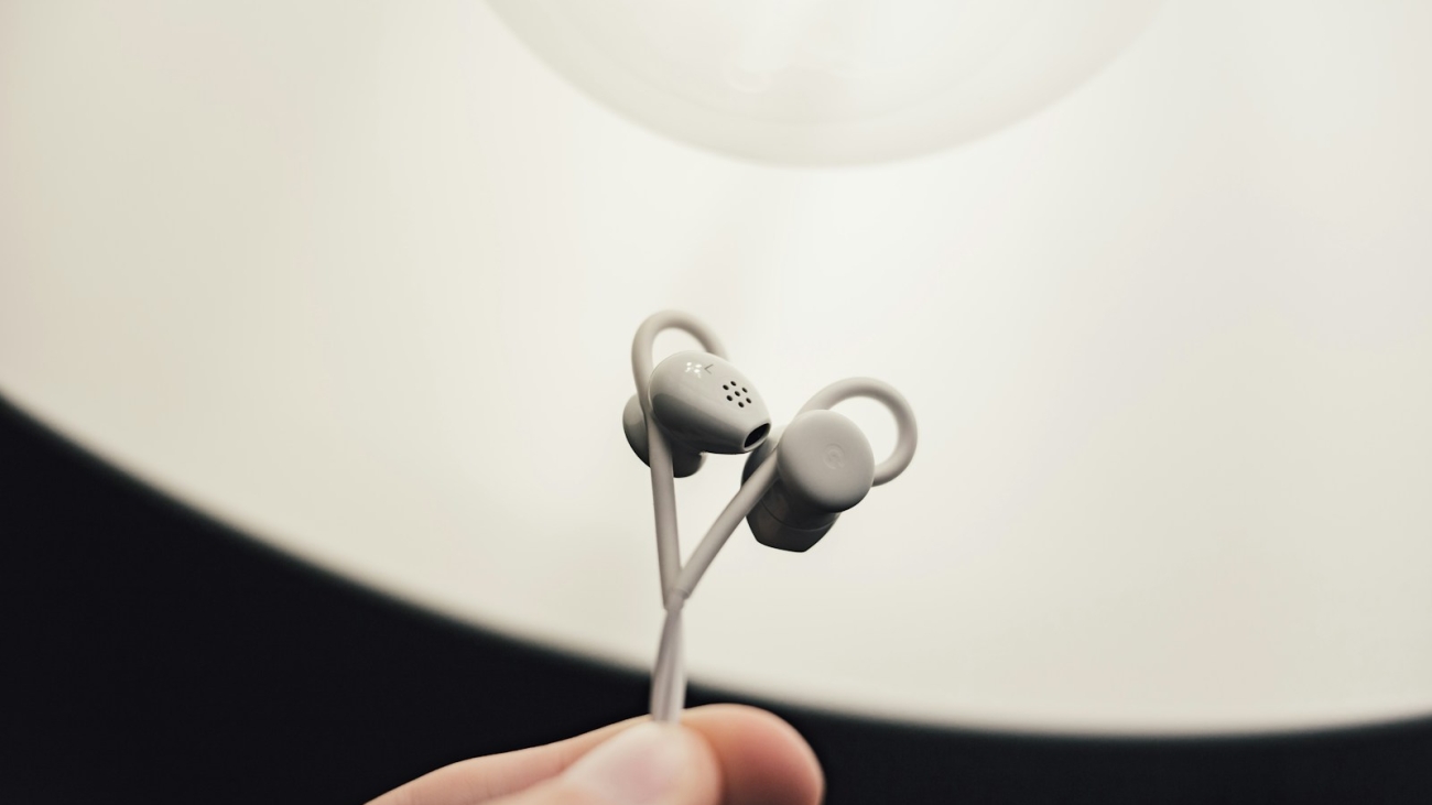 person holding gray earphones