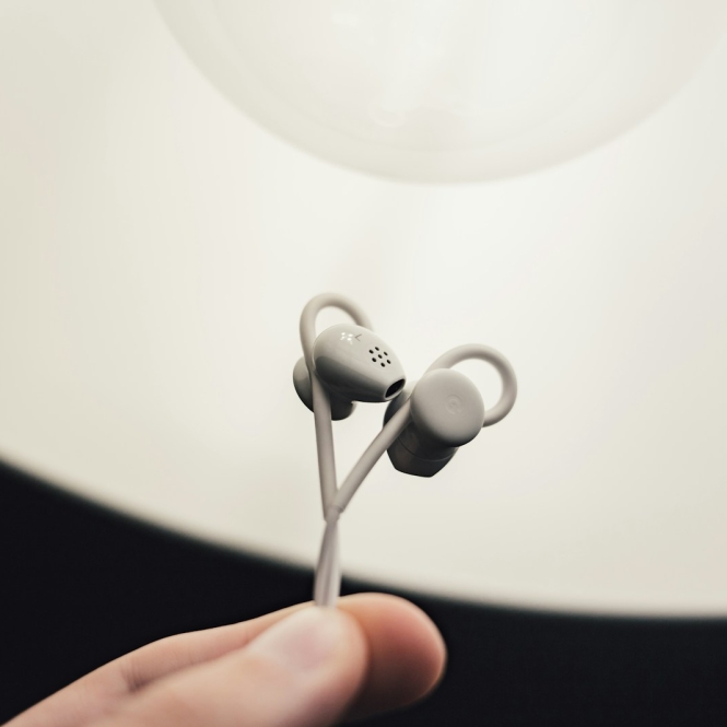 person holding gray earphones