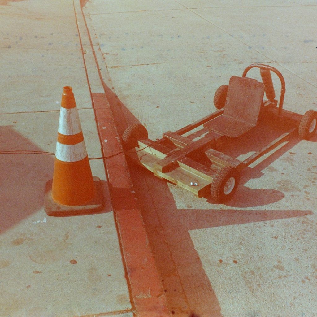 a small cart sitting on the side of a road next to a traffic cone