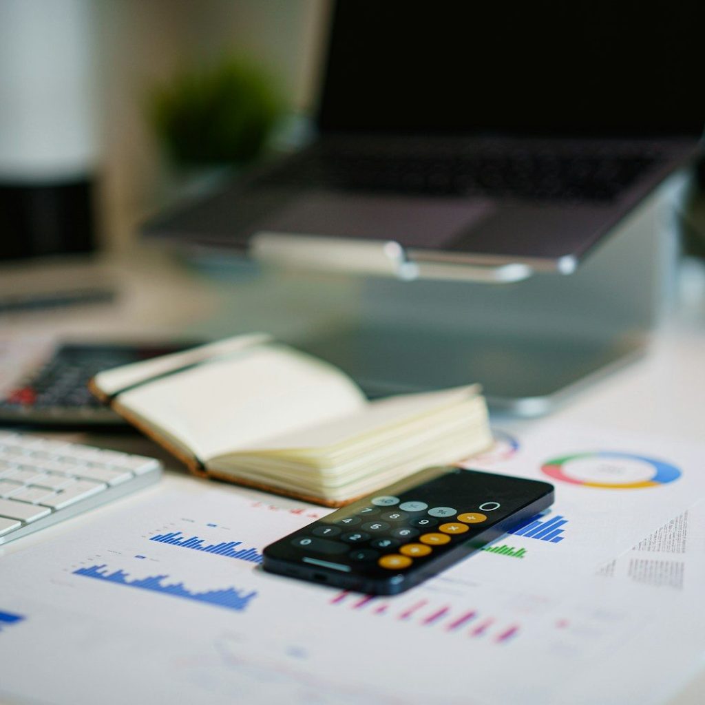 office desk with smartphone and financial charts