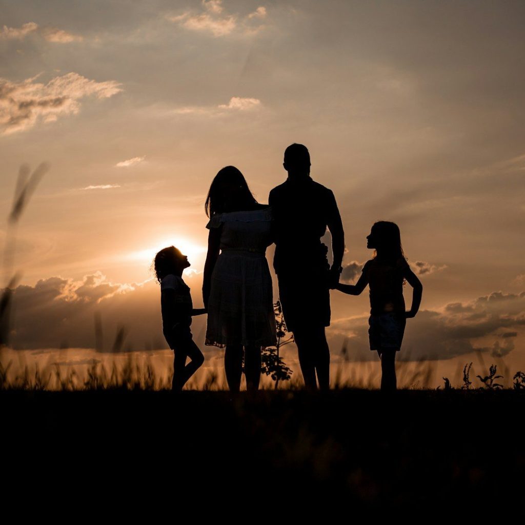 a family standing in a field at sunset