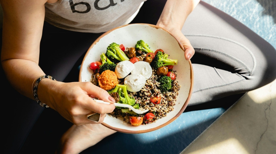 a woman is holding a bowl of food