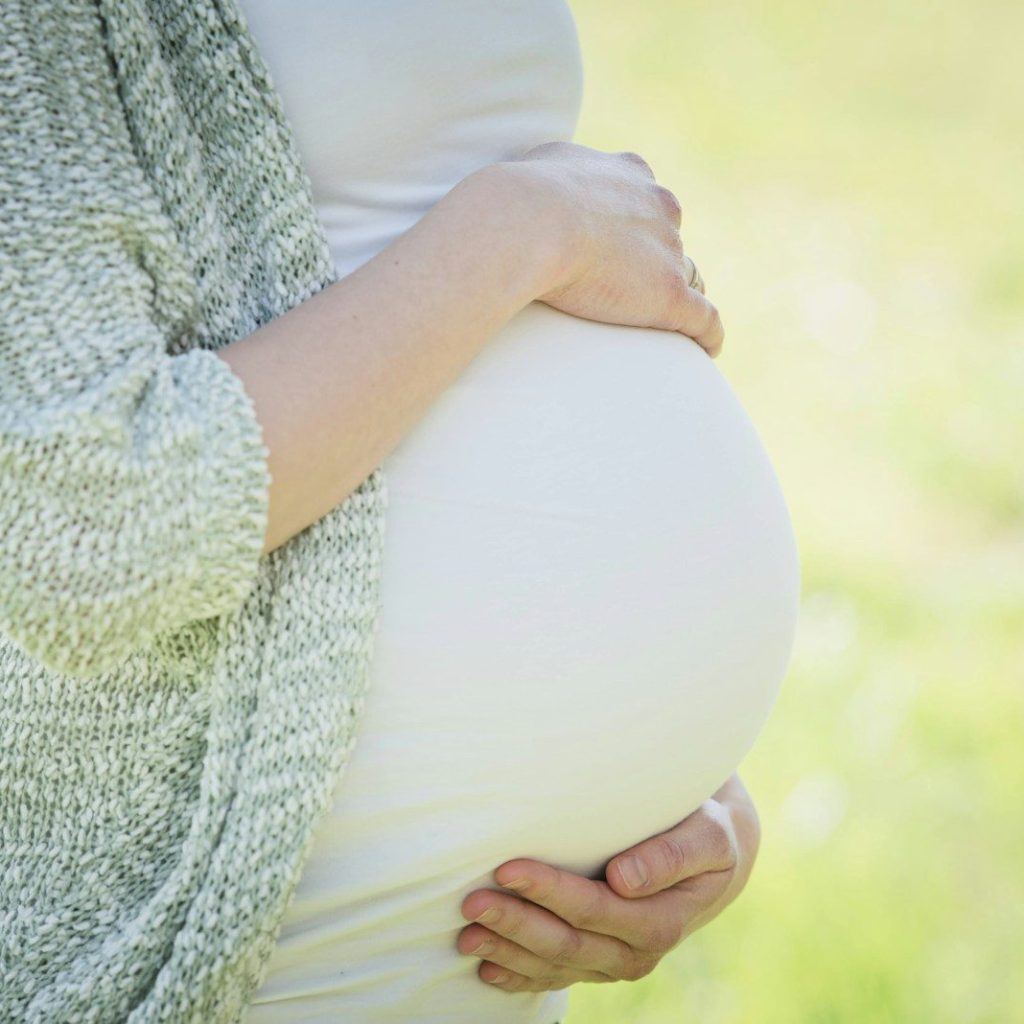 a pregnant woman holding her belly in her hands