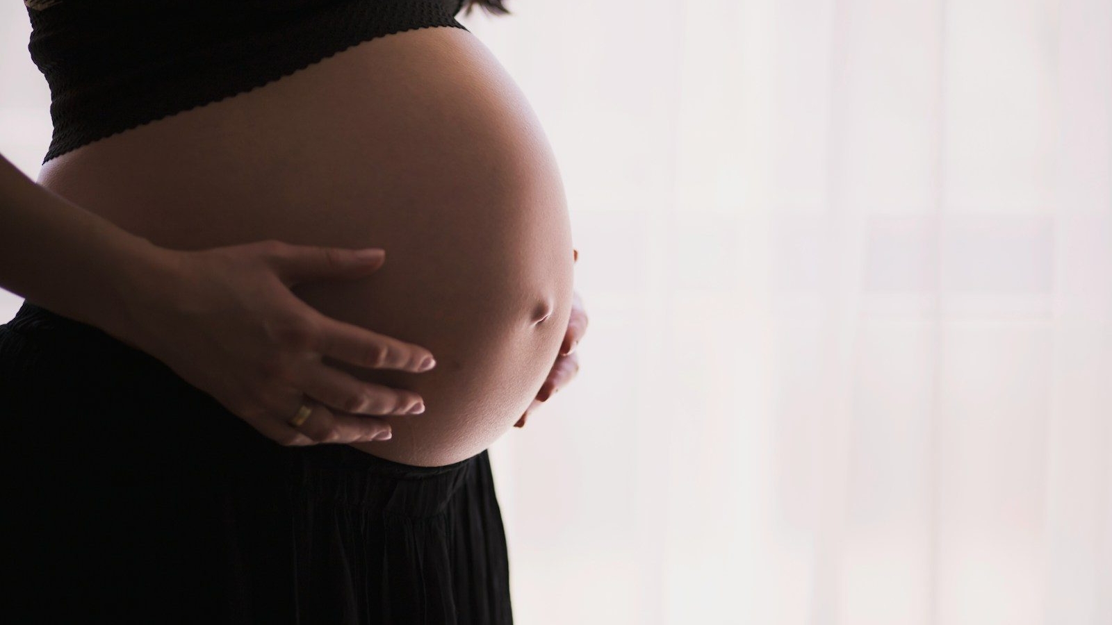 pregnant woman cradling her belly